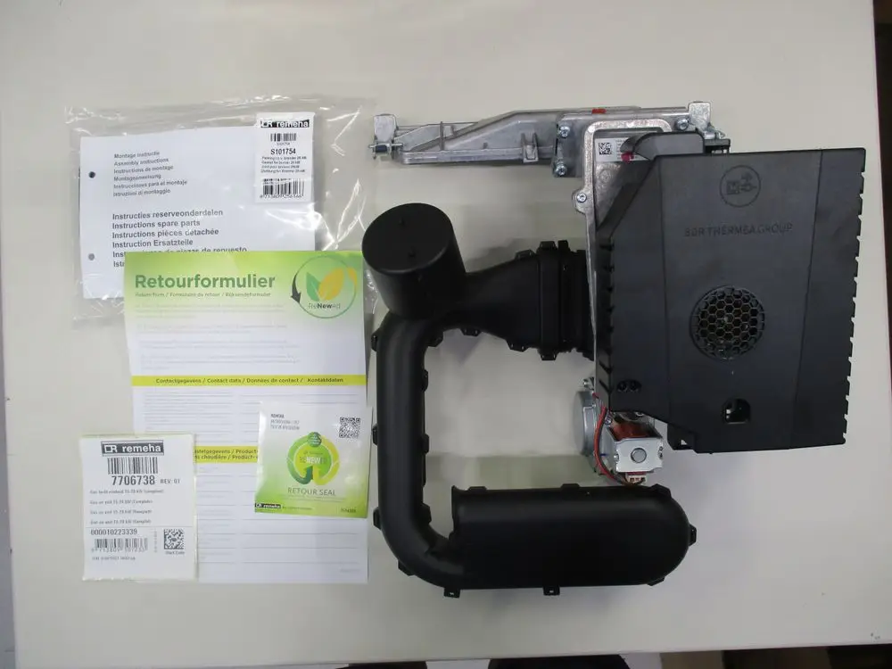 Gasgebläse von Remeha mit montierter PCB-Platine und Ventil, Bedienanleitungen und Rücksendeformular auf hellem Untergrund.